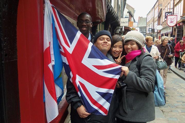 三个学生举着英国国旗